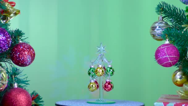 Green Background Small Christmas Tree Rotates Large Christmas Trees Decorated — Stock video