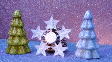 Decoration of stars near the cones between the decorative Christmas trees on a colored background