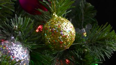 Siyah bir arka planda, yanıp sönen ışıkları olan büyük, güzel bir Noel ağacı.