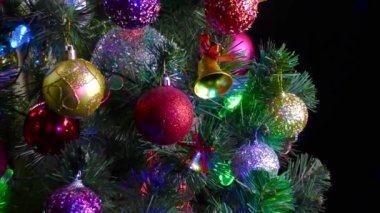 Siyah bir arka planda, yanıp sönen ışıkları olan büyük, güzel bir Noel ağacı.