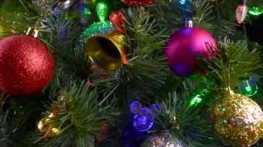 Siyah bir arka planda, yanıp sönen ışıkları olan büyük, güzel bir Noel ağacı.
