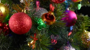 Siyah bir arka planda, yanıp sönen ışıkları olan büyük, güzel bir Noel ağacı.