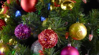 Siyah bir arka planda, yanıp sönen ışıkları olan büyük, güzel bir Noel ağacı.