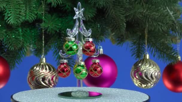 Een Blauwe Achtergrond Een Kleine Kerstboom Draait Buurt Van Een — Stockvideo
