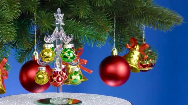 Een Blauwe Achtergrond Een Kleine Kerstboom Draait Buurt Van Een — Stockvideo