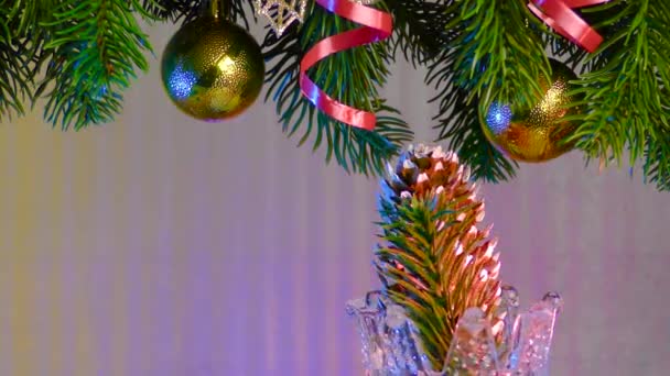 Een Gekleurde Achtergrond Onder Kerstboomtakken Met Kerstversiering Draait Een Mooie — Stockvideo