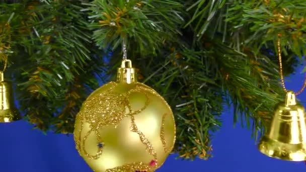 Gałęzie Choinkowe Ozdobione Dekoracjami Świątecznymi Obracają Się Niebieskim Tle — Wideo stockowe
