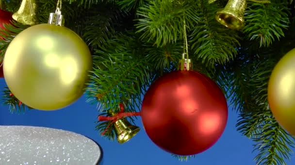 Een Blauwe Achtergrond Bij Kerstboomtakken Met Kerstversiering Draait Een Kleine — Stockvideo