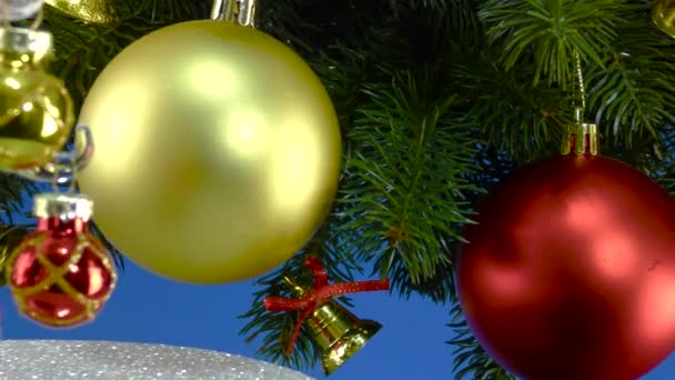 Een Blauwe Achtergrond Bij Kerstboomtakken Met Kerstversiering Draait Een Kleine — Stockvideo
