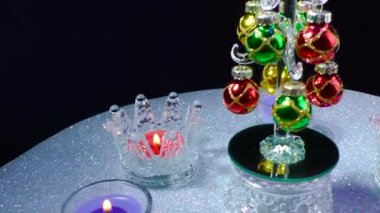 Küçük bir Noel ağacının etrafındaki gri bir yüzeyde, standlarda yanan mumlar.