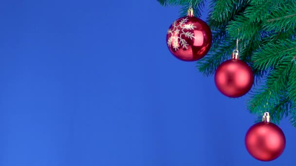 Auf Blauem Hintergrund Ein Zweig Mit Weihnachtsdekoration — Stockvideo
