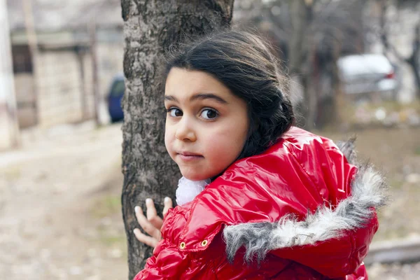 Menina em casaco vermelho e uma árvore . — Fotografia de Stock