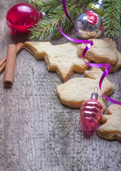 Gingerbread cookies and chrismas decorations over wooden backgr — Stock Photo, Image