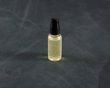 Siyah arka planda siyah bir sıvı bulunan bir şişe yağ..