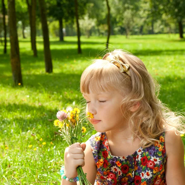 Csokor virág illatú szép kis lány portréja — Stock Fotó