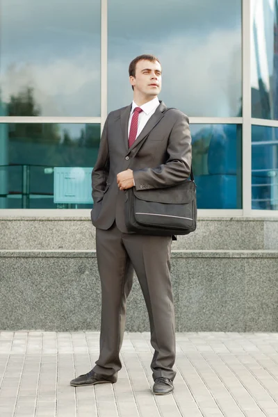 Бизнесмен, стоящий с мешком для ноутбука на плече — стоковое фото