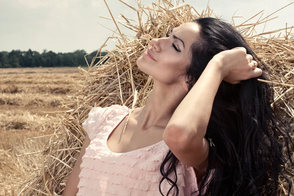 สาวสวยบนกองหญ้า — ภาพถ่ายสต็อก