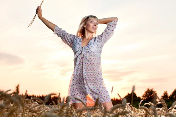 Schöne Frau zu Fuß auf Weizenfeld — Stockfoto