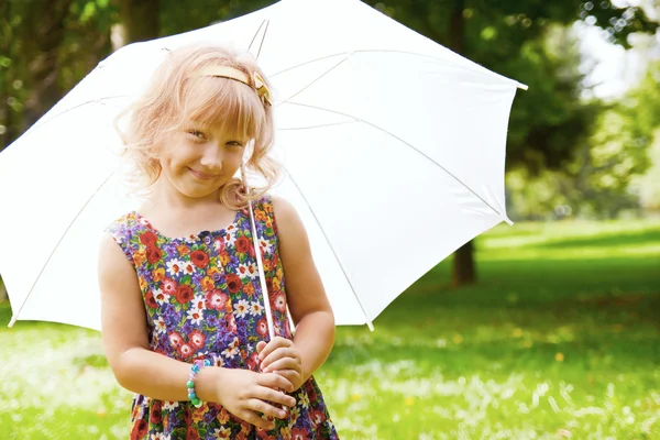 Girl under umbrella in the park — Stock Photo, Image