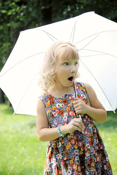 Little girl in the park under umbrella — Stock Photo, Image