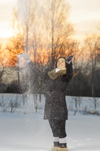 Όμορφη γυναίκα που παίζει με το χιόνι — Φωτογραφία Αρχείου