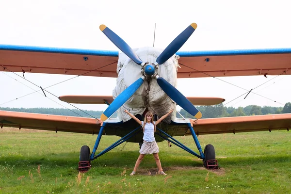 Schönes Mädchen steht in der Nähe des Flugzeugs — Stockfoto