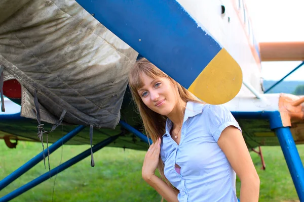 Mooi meisje staat in de buurt van het vliegtuig — Stockfoto