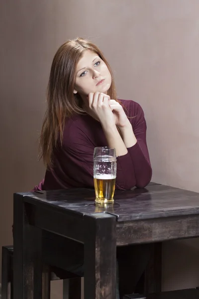 Menina solitária sentada a uma mesa — Fotografia de Stock