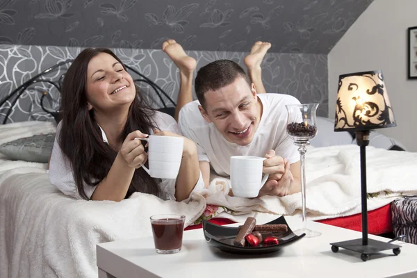 Breakfast on a table with couple lying — Stock Photo, Image