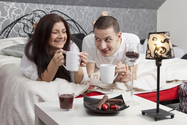 Breakfast on a table with couple lying — Stock Photo, Image