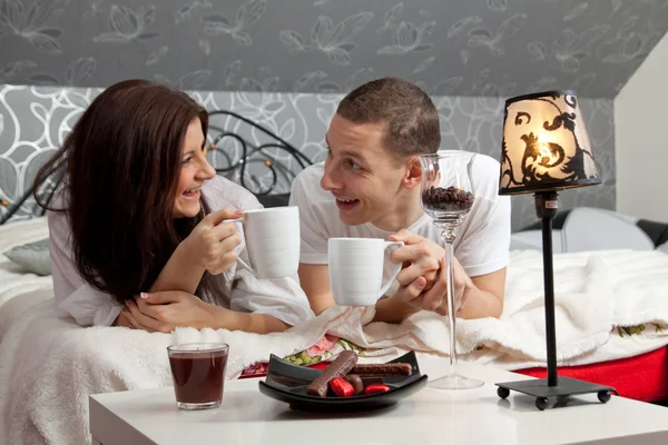 Breakfast on a table with couple lying — Stock Photo, Image