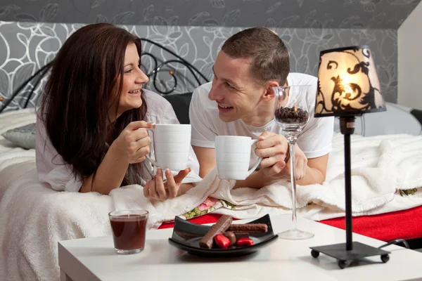 Colazione su un tavolo con coppia sdraiata — Foto Stock