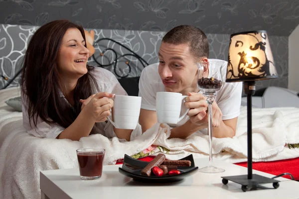 Breakfast on a table with couple lying — Stock Photo, Image