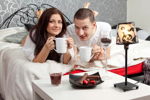 Breakfast on a table with couple lying — Stock Photo, Image