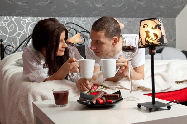 Breakfast on a table with couple lying — Stock Photo, Image