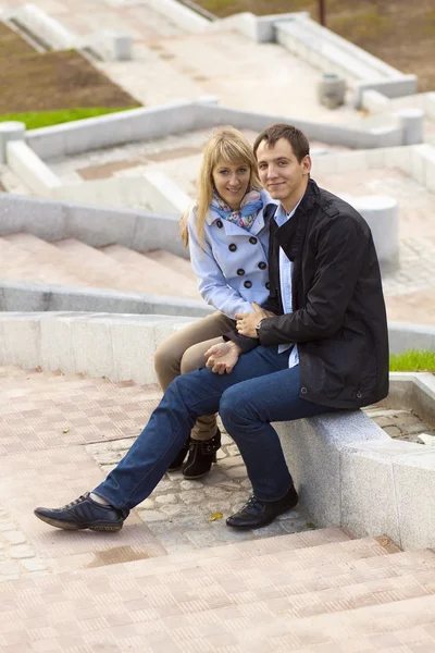 Happy young couple sitting on stairs — Stock Photo, Image