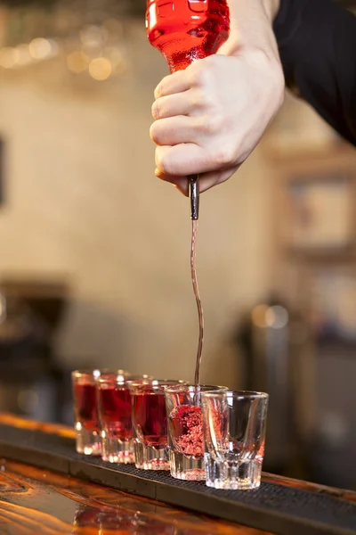 Barman vult een paar glazen in een rij — Stockfoto