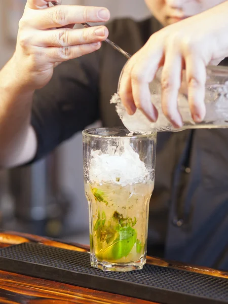 Barman stromende ijs in glas — Stockfoto