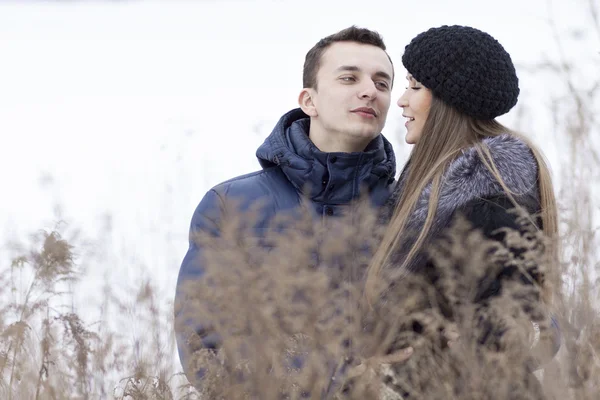 Jovem casal feliz no campo de inverno — Fotografia de Stock