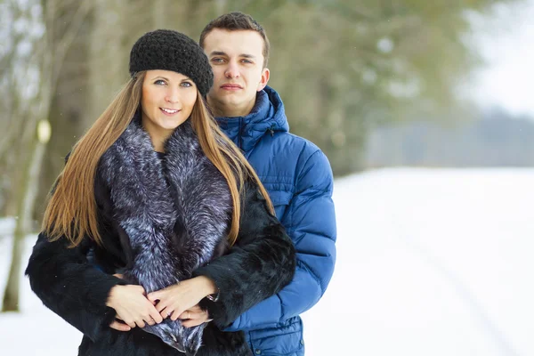 Счастливая молодая пара в Зимнем парке веселится — стоковое фото