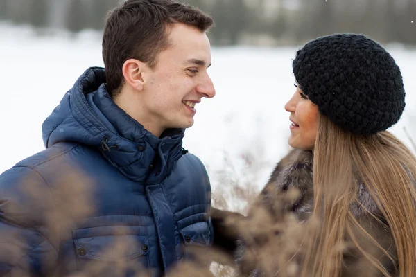 Joyeux jeune couple en champ d'hiver — Photo