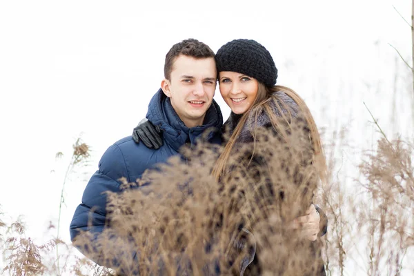 Jovem casal feliz no campo de inverno — Fotografia de Stock