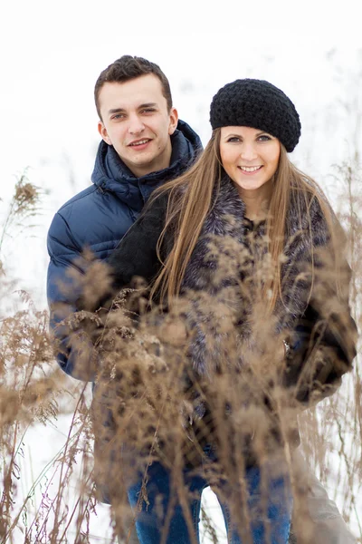 Joyeux jeune couple en champ d'hiver — Photo