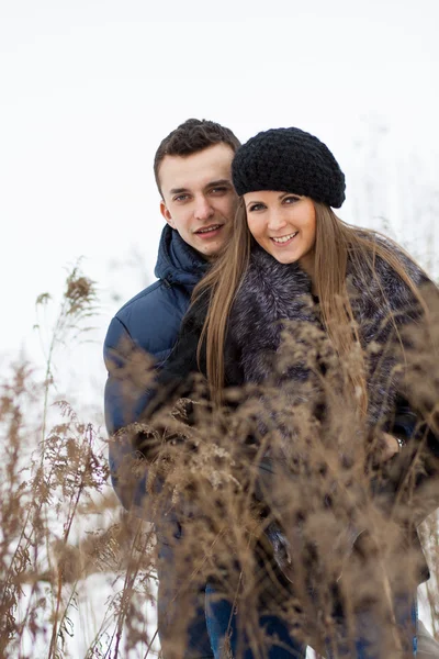 Jovem casal feliz no campo de inverno — Fotografia de Stock