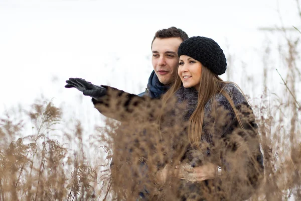 Joyeux jeune couple en champ d'hiver — Photo