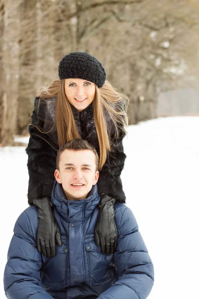 Счастливая молодая пара в Зимнем парке веселится — стоковое фото