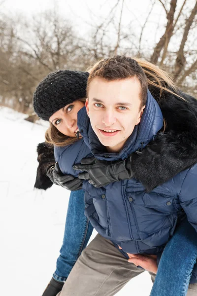 A família jovem joga madeira de inverno na neve — Fotografia de Stock