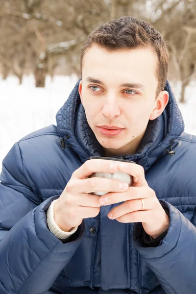 Człowiek rozgrzewając się przy gorącej herbaty — Zdjęcie stockowe