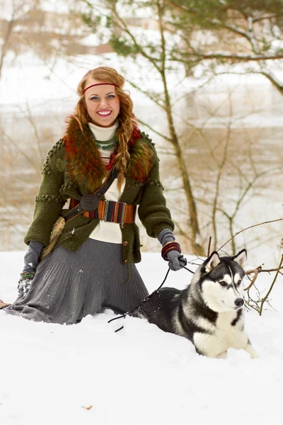 快乐的年轻女人坐着西伯利亚爱斯基摩狗 — 图库照片