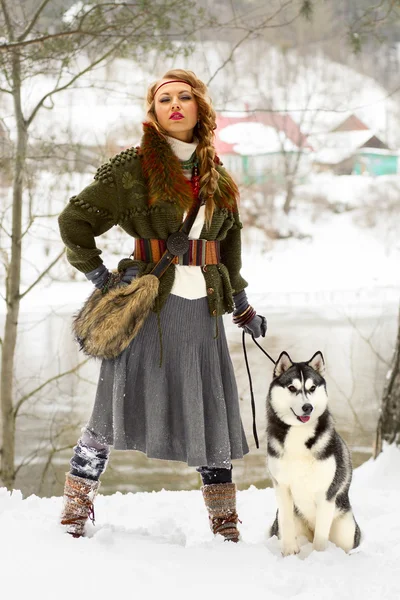 Szczęśliwa młoda kobieta stojąc z psem husky syberyjski — Zdjęcie stockowe